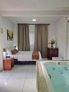 ein Hotelzimmer mit einem Bett und einer Badewanne in der Unterkunft Casa de Férias Casa Mia in Santa Cruz Cabrália