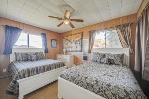 a bedroom with two beds and a ceiling fan at Rustic and Western House on Lake - Swim, Fish, Hunt! in Llano