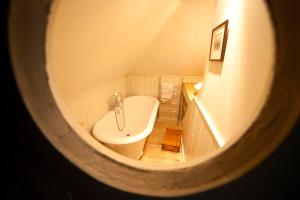 a view of a bathroom with a tub and a toilet at The Lodge: Adorable, Romantic Thatched Cottage in Freshwater