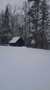 a barn in a field covered in snow at Zirgu sēta "Klajumi" - Horse ranch "Klajumi" in Kaplava