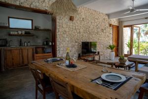 a living room with a wooden table and a kitchen at Natural Park Villa Resort in Pingwe