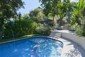 Designer Pool Villa Under the Hollywood Sign في لوس أنجلوس: مسبح في ساحة فيها مظلة