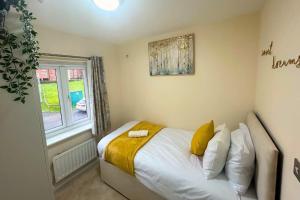 a small bedroom with a bed and a window at Luxury Home near NEC, BHX with Parking and Netflix in Solihull