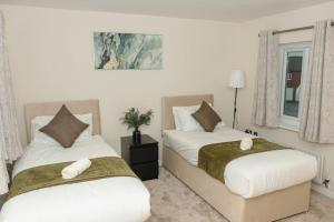 a bedroom with two beds and a window at Luxury Home near NEC, BHX with Parking and Netflix in Solihull