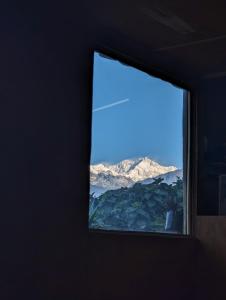 ventana en una habitación con vistas a la montaña en Mochilero Ostello, en Pelling