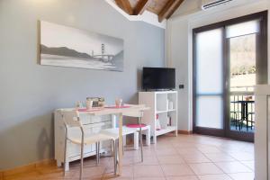 - un salon avec une table, des chaises et une télévision dans l'établissement Relax Tra Monti e Laghi, à Brenta