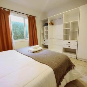 1 dormitorio blanco con 1 cama grande y ventana en Depto Ushuaia (Otero) en Ushuaia