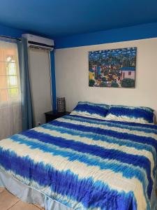 a blue bedroom with a bed with a blue and white comforter at Uverito Sand Dollar B&B in Las Tablas