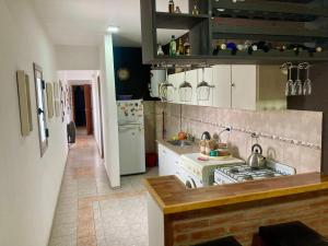 a kitchen with a stove and a white refrigerator at Departamento Ludmila in Villa María +4 photos