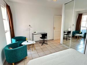 a living room with blue chairs and a table at Nice apartment Duque Tenerife South in Adeje