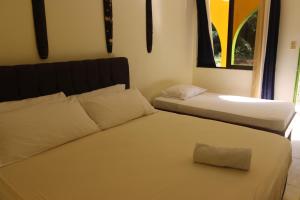 1 dormitorio con 2 camas y ventana en Cool & Calm Hotel, en Manzanillo