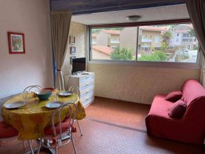 uma sala de estar com uma mesa e um sofá em 3VSE-COB3 Studio équipé pour 2-3 personnes proche de la plage em Collioure
