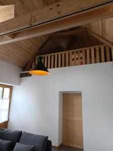 Longère Mille et une roses في Chédigny: غرفة معيشة مع أريكة سوداء وسقف خشبي