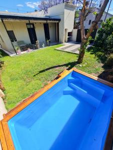 una piscina azul frente a una casa en Lechuza Bolivar en San Antonio de Areco