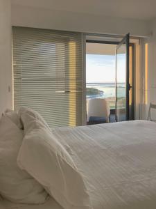 a bedroom with a bed and a view of the ocean at Del Mar Village, Apartment T1 , Açor in Fuzeta
