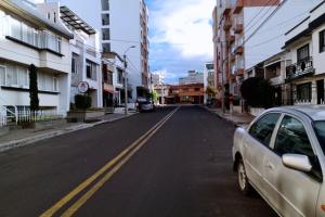 een lege straat met een auto op de weg bij Hostal Habitaciones de la 39 in Pasto