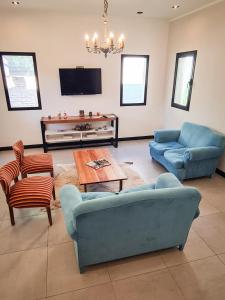 sala de estar con sofás, mesa y TV en Lechuza Bolivar en San Antonio de Areco