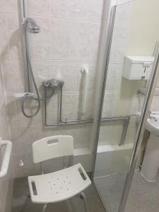 a bathroom with a shower with a toilet and a sink at Salfordian in Southport