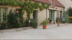 ein Haus mit Pflanzen und Blumen davor in der Unterkunft Chambres et Table d'hôtes Cerviña in Châteauneuf-sur-Loire
