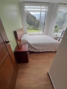 a bedroom with a bed and a large window at Moderna casa vacacional en Baños in Juivi