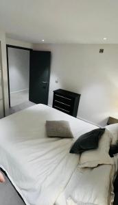 a bedroom with a large white bed with pillows at Trendy & Chic Apartment In The Heart of London in London