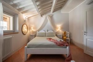 sypialnia z białym łóżkiem i oknem w obiekcie Il Cantinone w mieście San Vincenzo