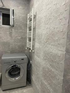 un baño junto a una pared con lavadora en Aldaga, en Tiflis
