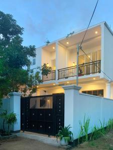 uma grande casa branca com um portão preto em Golden Wave em Ahangama