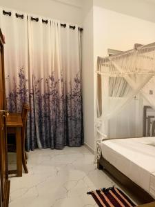 阿漢伽馬的住宿－Golden Wave，一间卧室配有床和窗帘