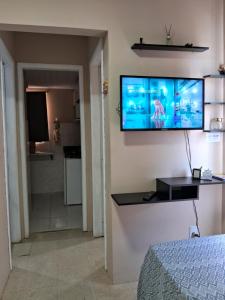 um quarto com uma televisão de ecrã plano na parede em apto bem localizado todo mobiliado em Foz do Iguaçu