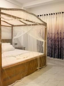 um quarto com uma cama de dossel e cortinas em Golden Wave em Ahangama
