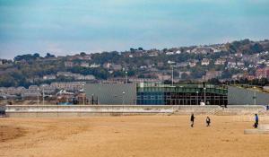 a group of people flying a kite in front of a building at Central Colwyn Bay F1 in Colwyn Bay
