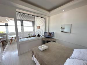 1 dormitorio con 1 cama, TV y ventana en Rio Flat 2 Copacabana Beach, en Río de Janeiro