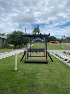 ein Park mit einer Bank im Gras in der Unterkunft Sítio Meu Refúgio in Cabo Frio