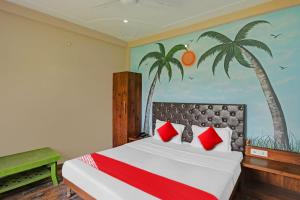 1 dormitorio con 1 cama con palmeras en la pared en OYO Flagship MH Inn en Varanasi