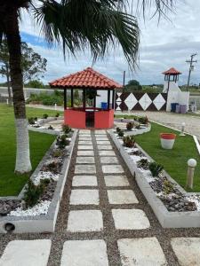 einen Garten mit einem Pavillon und einer Palme in der Unterkunft Sítio Meu Refúgio in Cabo Frio