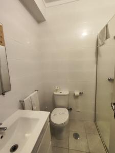 a bathroom with a toilet and a sink and a tub at Residencial Centro Comercial Avenida Bragashopping in Braga