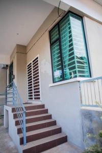 eine Treppe, die zu einem Gebäude mit einem Fenster führt in der Unterkunft CikJah Guest House SEMI-D in Kuantan