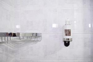 a white tiled bathroom with a soap dispenser on a wall at Your Home, in the center of Bari in Bari