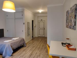 una camera con tavolo, letto e tavolo e una camera con di Residencial Centro Comercial Avenida Bragashopping a Braga