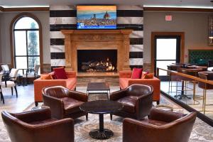 eine Lobby mit Stühlen und einem Kamin mit einem TV in der Unterkunft Delta Hotels by Marriott Indianapolis East in Indianapolis