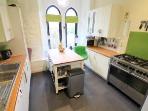 a kitchen with white cabinets and a stove top oven at Newton Hall in Inveraray