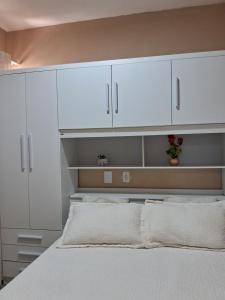 um quarto com armários brancos e uma cama em apto bem localizado todo mobiliado em Foz do Iguaçu