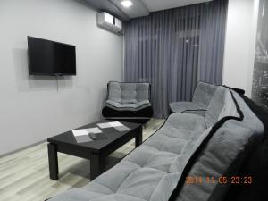 sala de estar con sofá y TV en Apartment VOX, en Batumi