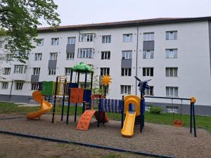 a playground in front of a large building at Anne Studio in Onești