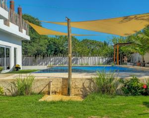 un dosel amarillo sobre una piscina en un patio en Villa Juliana Monterrico, en Taxisco