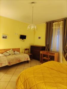 een slaapkamer met een bed, een bureau en een televisie bij Bed and Breakfast La Campanula in Vittorito