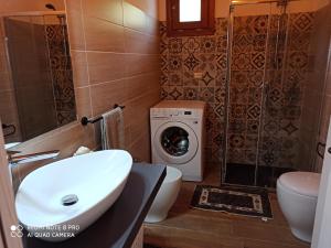 een badkamer met een wastafel en een wasmachine bij Villetta Smeralda in La Caletta