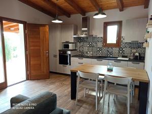 cocina con mesa de madera y sillas en una habitación en Villetta Smeralda en La Caletta