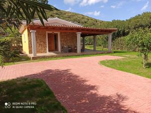 een klein huis met een paviljoen in een tuin bij Villetta Smeralda in La Caletta